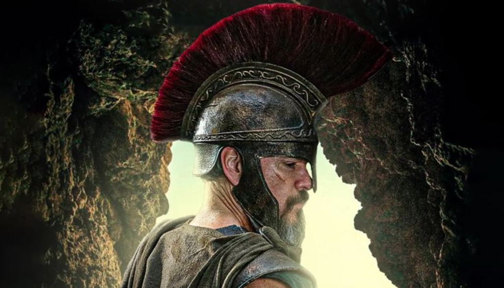 Matt Damon as Odysseus in official photo from Christopher Nolan's The Odyssey wearing red-plumed Corinthian helmet and warrior costume